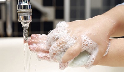 Soapy hands of little child hand-washing in the sink